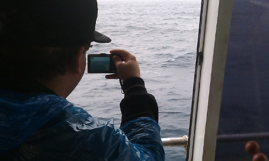 A CNU student stands by to snap a humpback whale surfacing on its migration north.