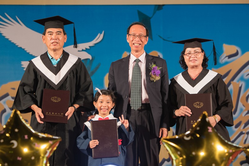 樂齡大學王萬全(左一)、楊綉朝(右一)及幼兒園代表畢業生上台撥穗