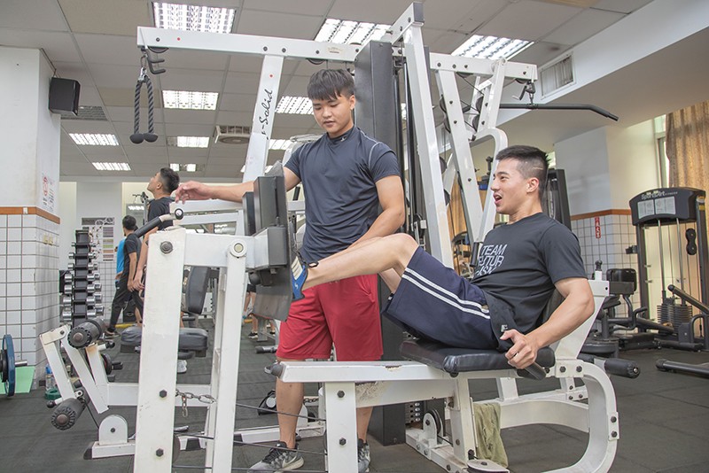 為了防止腿部肌肉萎縮，胡良宇每天必到健身房報到，運管系廖俞翔(左)便是他運動健身的好夥伴