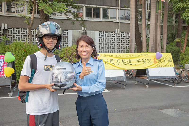 慢騎趣味競賽獲勝同學，由嘉藥生輔組長戴金梅（右）頒贈全罩式安全帽獎品