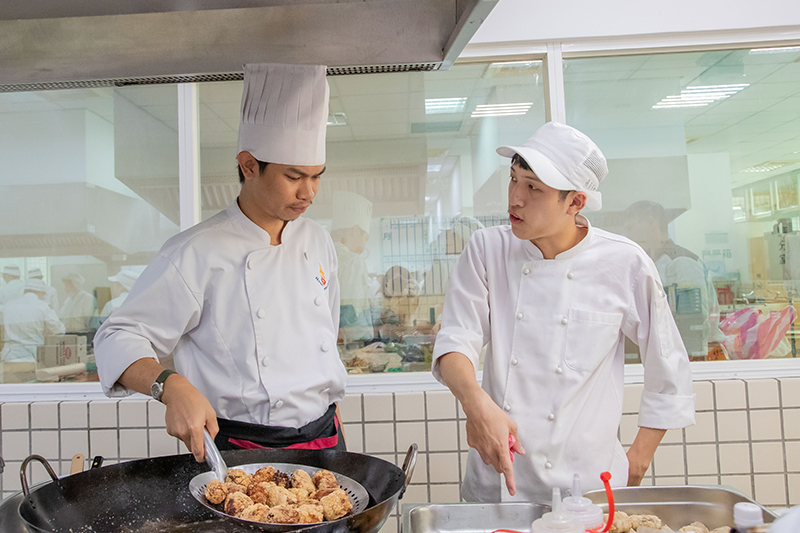 泰國短期留學生阿丹(左)負責古早味肉圓及菱角酥製作