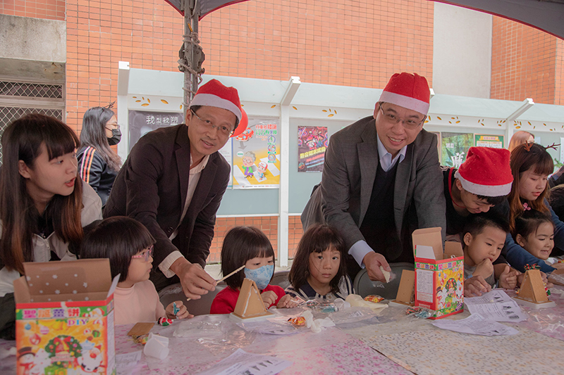 嘉藥副校長廖志祥及國際長萬孟瑋(左至右)陪同幼童一起製作薑餅屋