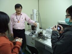 Industry teacher Lin Wu-sheng, and engineer, demonstrates a scanning electron microscope (SEM)