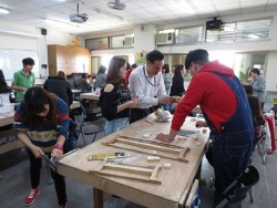 Professor Sun Tzu-Yi guides students in the production of wooden toys