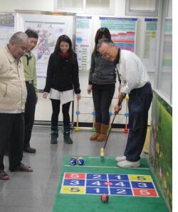 Students leading elderly citizens in a croquet activity