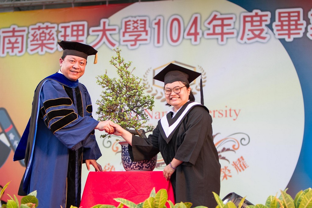 畢業生代表楊雅婷(右)回贈學校培育四年的校苗