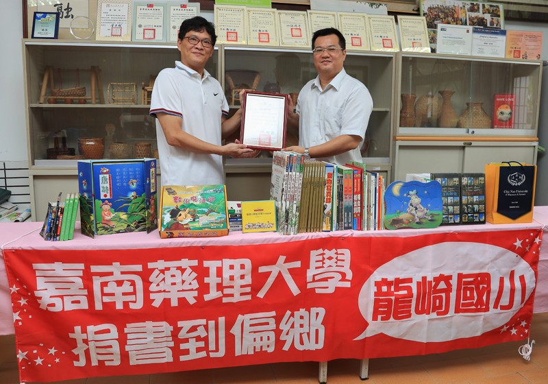嘉藥圖資館館長薛雅明（右）接受龍崎國小洪敬堯主任（左）致贈感謝狀
