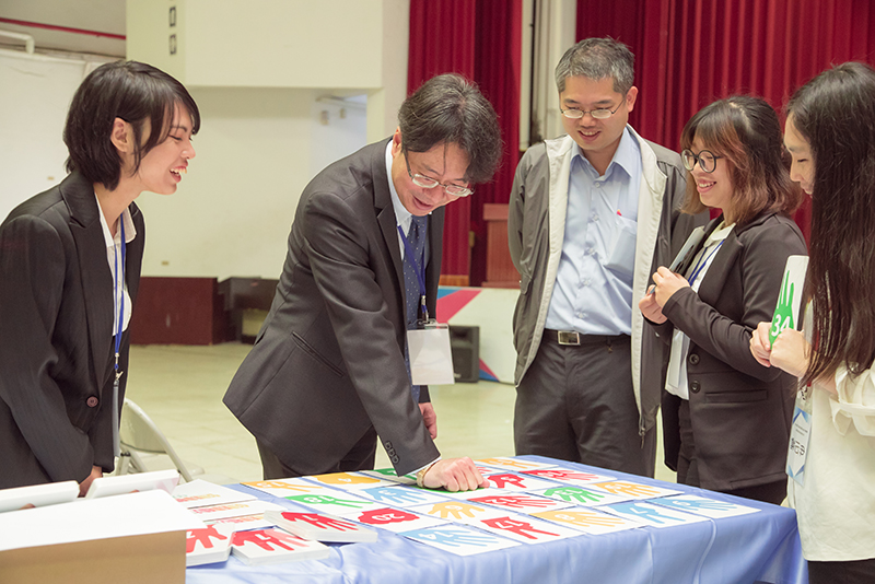 休閒學院董志明院長(左二)現場體驗學生製作的銀髮桌遊