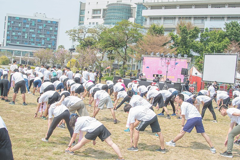 大家不畏烈日在嘉南廣場上為路跑暖暖身(攝影社張晉維拍攝)