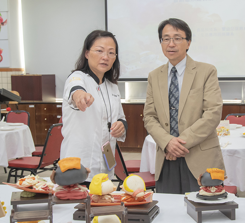 孫靖玲老師（左）向校長陳鴻助解說創意作品