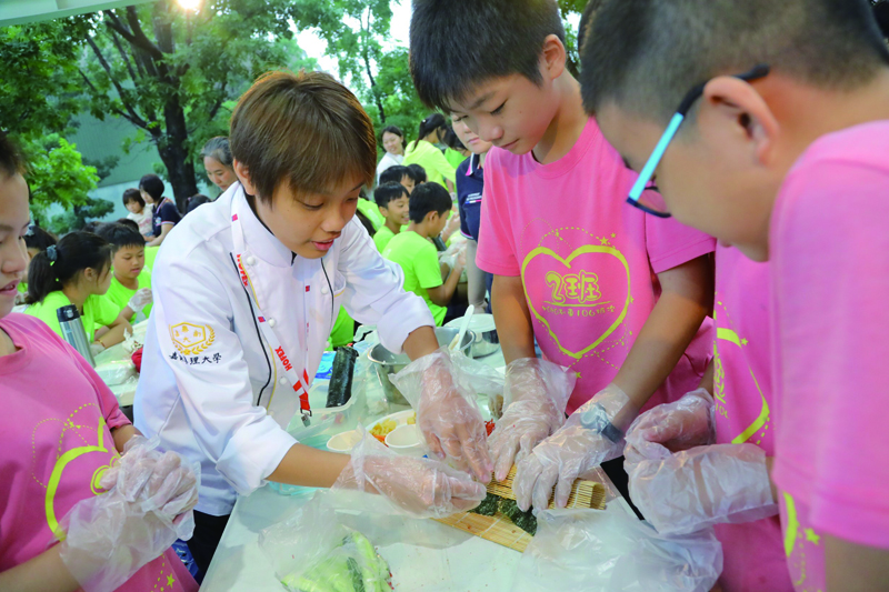 嘉藥餐旅系學生教導紅瓦厝國小學童包壽司技巧