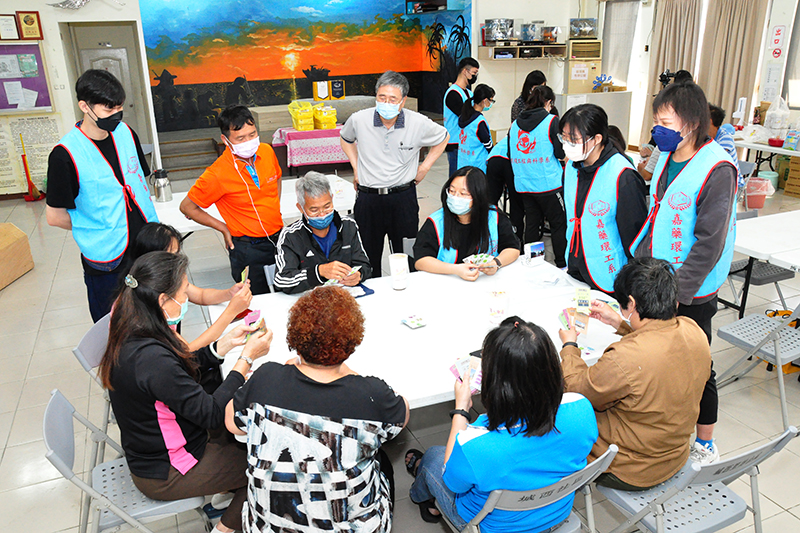 社區里民與學生一起體驗桌遊，李得元老師現場指導