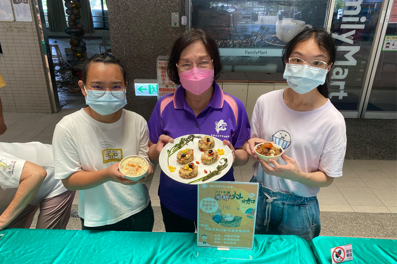 嘉藥營養系吳宜真(右)、邱于菁(左)同學與張月柑阿嬤(中)以餐點營養特色抱得「創意獎」