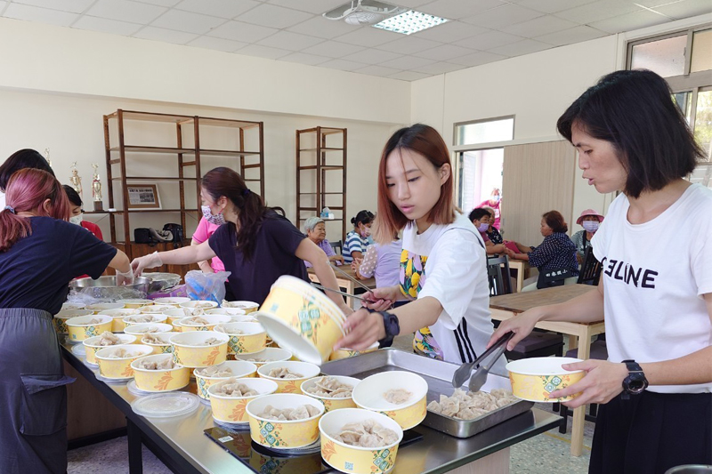 同學與社區志工及里長一起進行餐點分裝，服務長輩