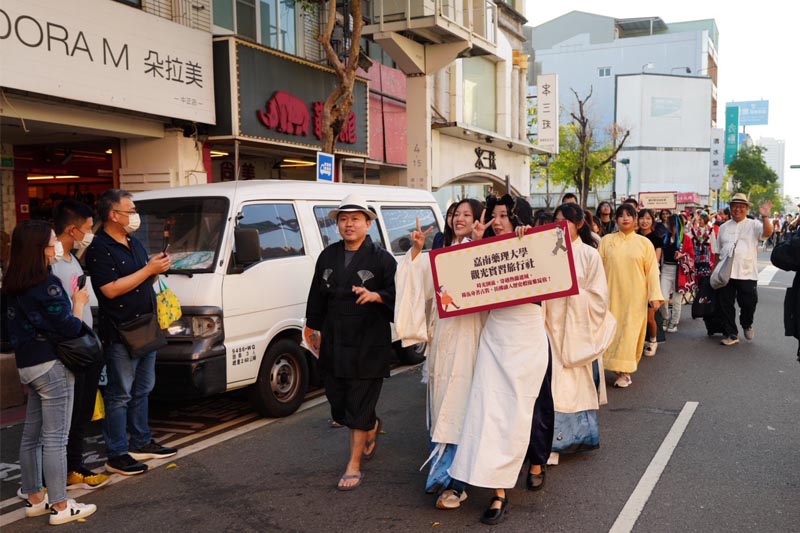 甘其銓主任（前排戴帽）帶領觀光系師生一同踩街遊行