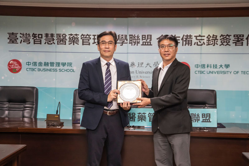 嘉南藥大副校長洪瑞祥(左)代表致贈嘉藥設計禮品給予中信科大教務長黃啟明