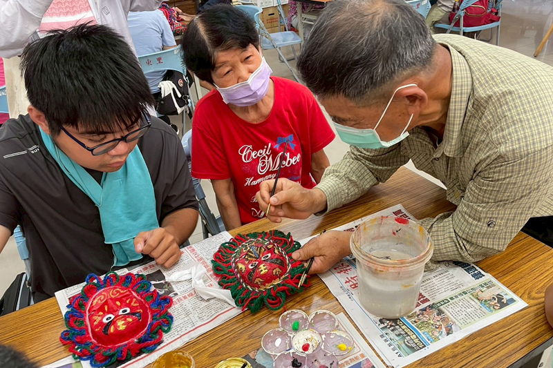謝俊煌老師耐心教導大學生與長輩製作面具的技巧