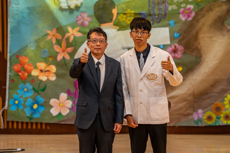 嘉藥校長張翊峰為學生代表陳煒翔披上白袍
