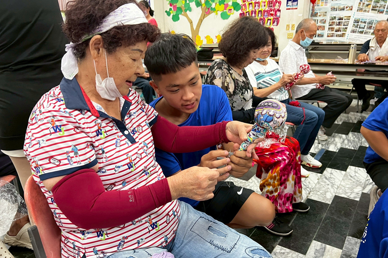 嘉藥學生一對一教導長輩製作艾草按摩搥