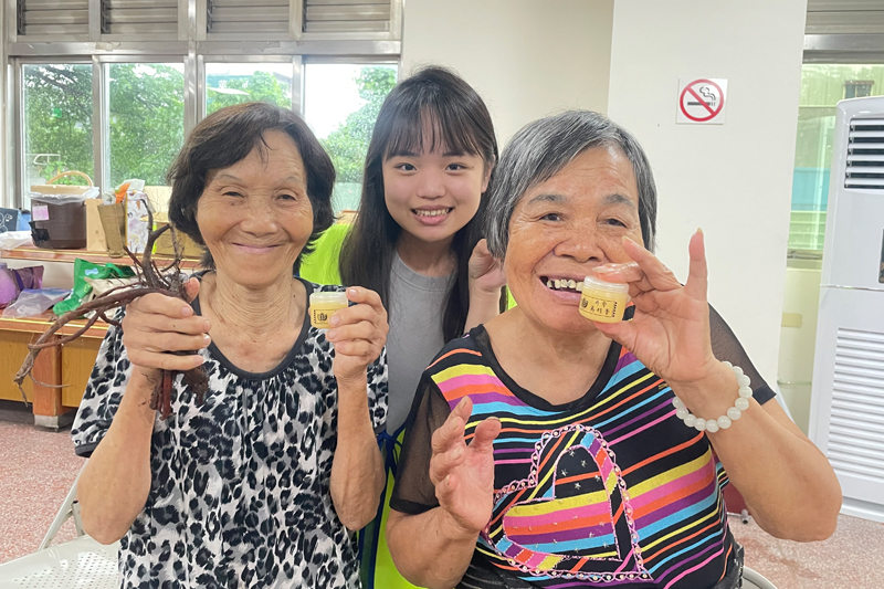 80歲楊阿嬤(左)開心在嘉藥學生協助下完成丹參萬金膏