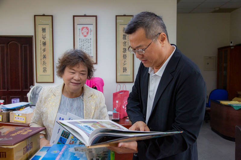 嘉藥館長薛雅明(右)向大甲國小蔡玉仙(中)解說贈致書冊內容