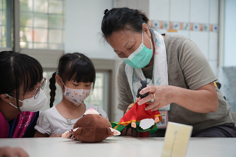 嘉藥大學生與長輩與帶領孩童體驗傳統布袋戲偶