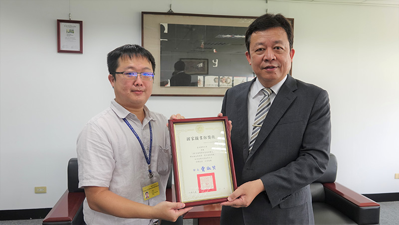 圖資館讀者服務組蕭博覺先生(左)獻獎給李孫榮校長(右)