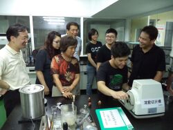 Professor Huang Hsiu-Chin guides students in the use of a rolling slicer